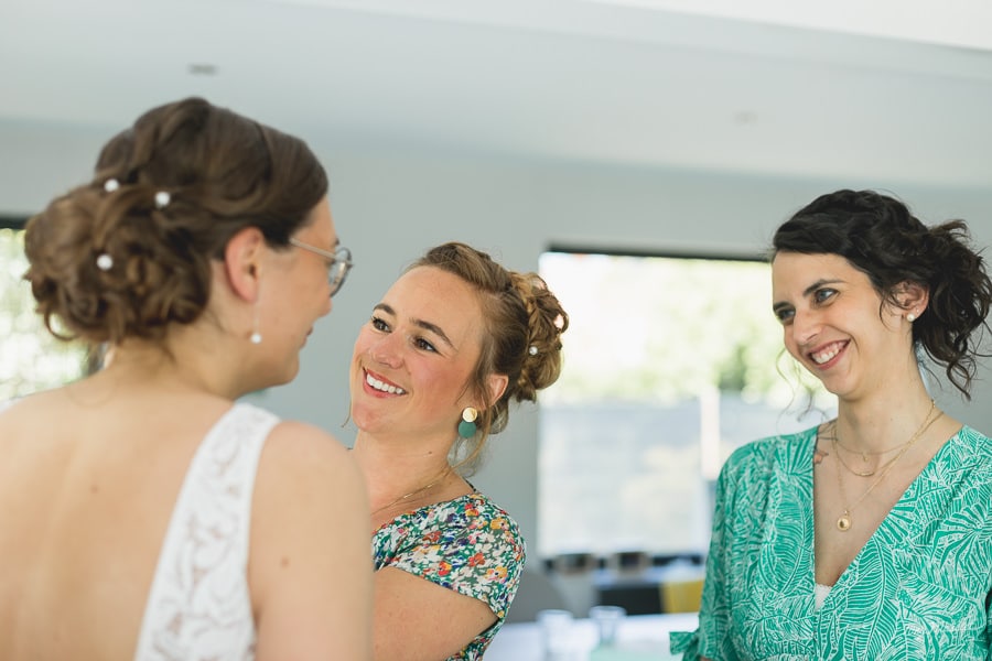 Deux témoins souriante regarde la mariée de dos 