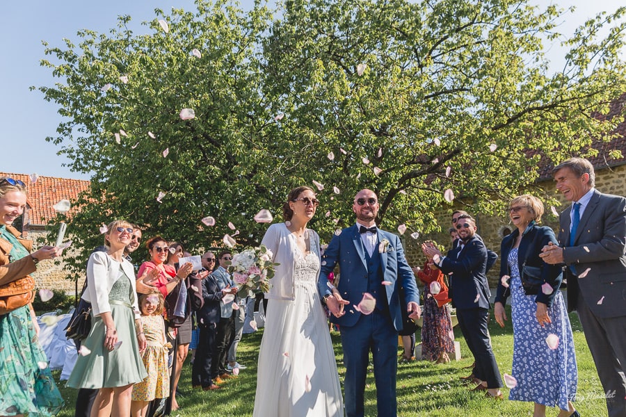 Sortie des mariés sous les pétales lancés par les invités à la fin de la cérémonie laïque le domaine La Maloterie à Belle et Houlefort