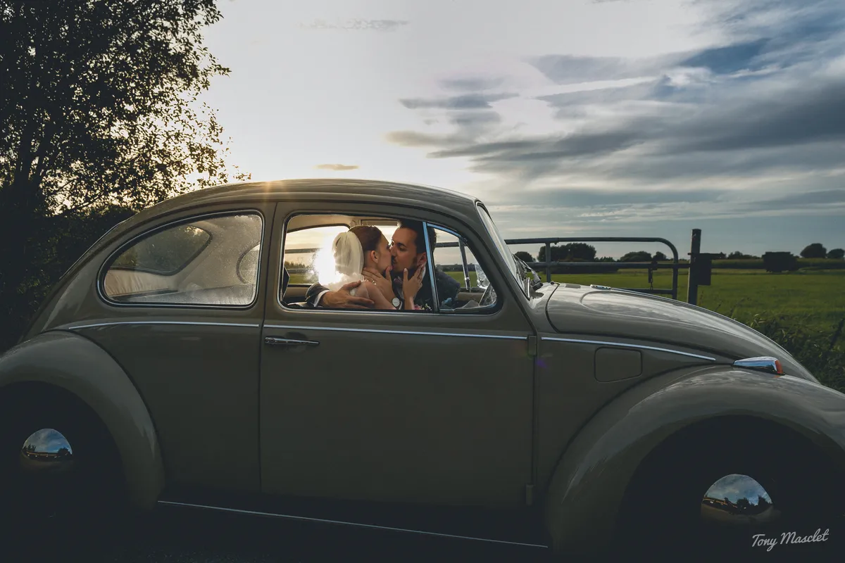 Mariage au Clos du Bac Nieppe – les mariés dans une coccinelle VW au coucher de soleil