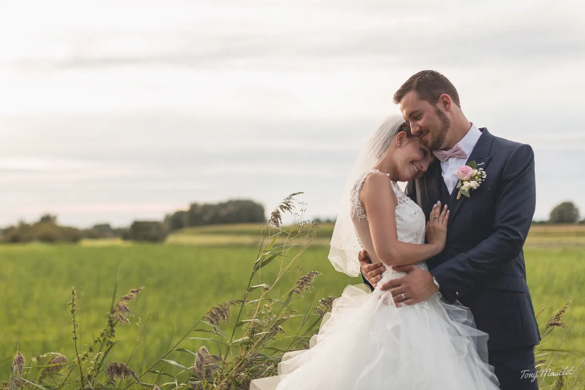 Photographe mariage Nieppe – couple enlacé dans les champs au coucher de soleil