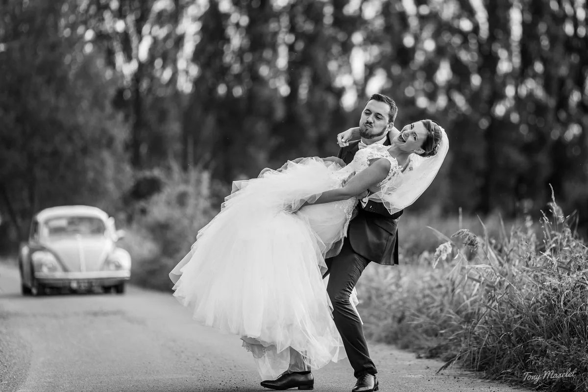 Mariage Clos du Bac Nieppe – le marié porte la mariée sur un chemin de campagne