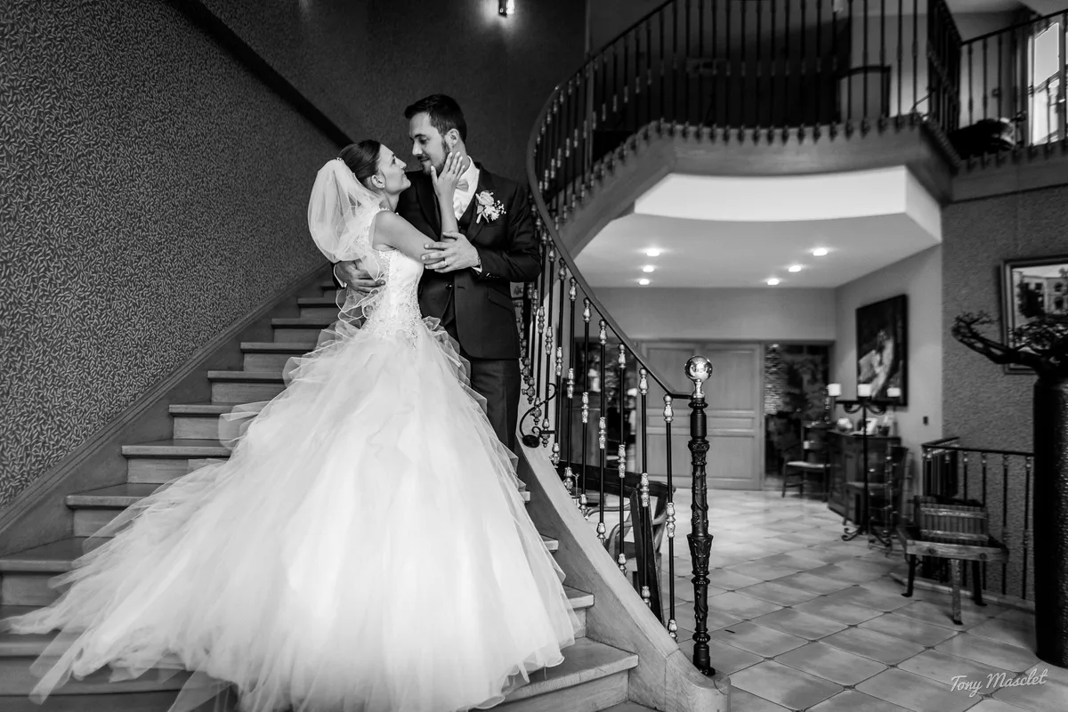 Mariage au Clos du Bac Nieppe – couple enlacé dans le grand escalier de la salle de réception
