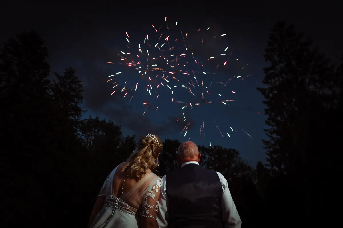 Couple de mariés au Pré Fleuri photographe mariage Arras feu d'artifice avec les mariés devant