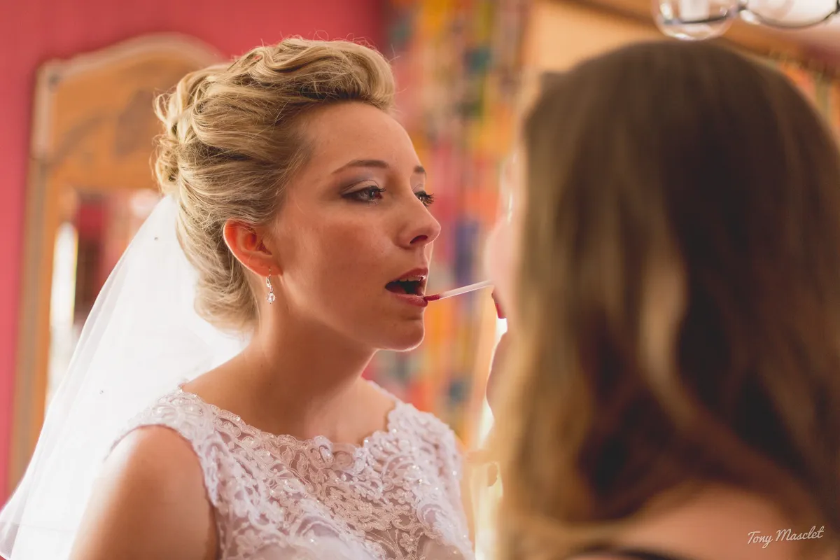 Photographe mariage Nieppe – maquillage de la mariée, application du rouge à lèvres