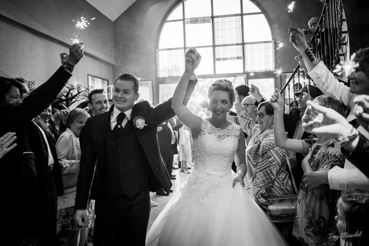 Photographe mariage Nieppe – entrée des mariés sous une haie d'honneur de cierges magiques