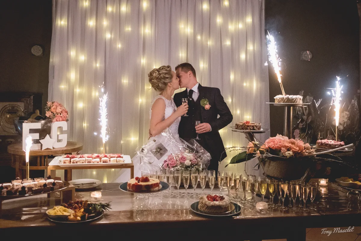 Photographe mariage Nieppe – baiser devant le buffet de desserts et la fontaine de champagne