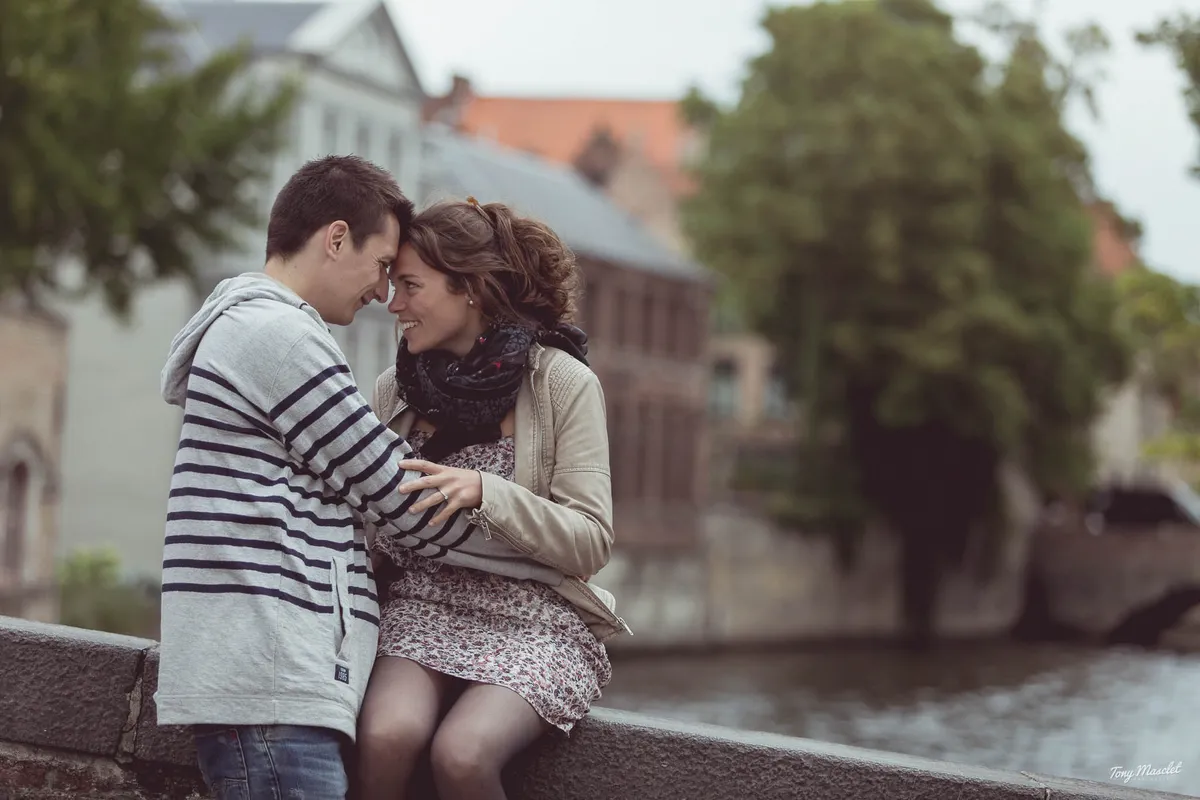 Séance engagement Bruges – couple enlacé devant les bâtiments historiques